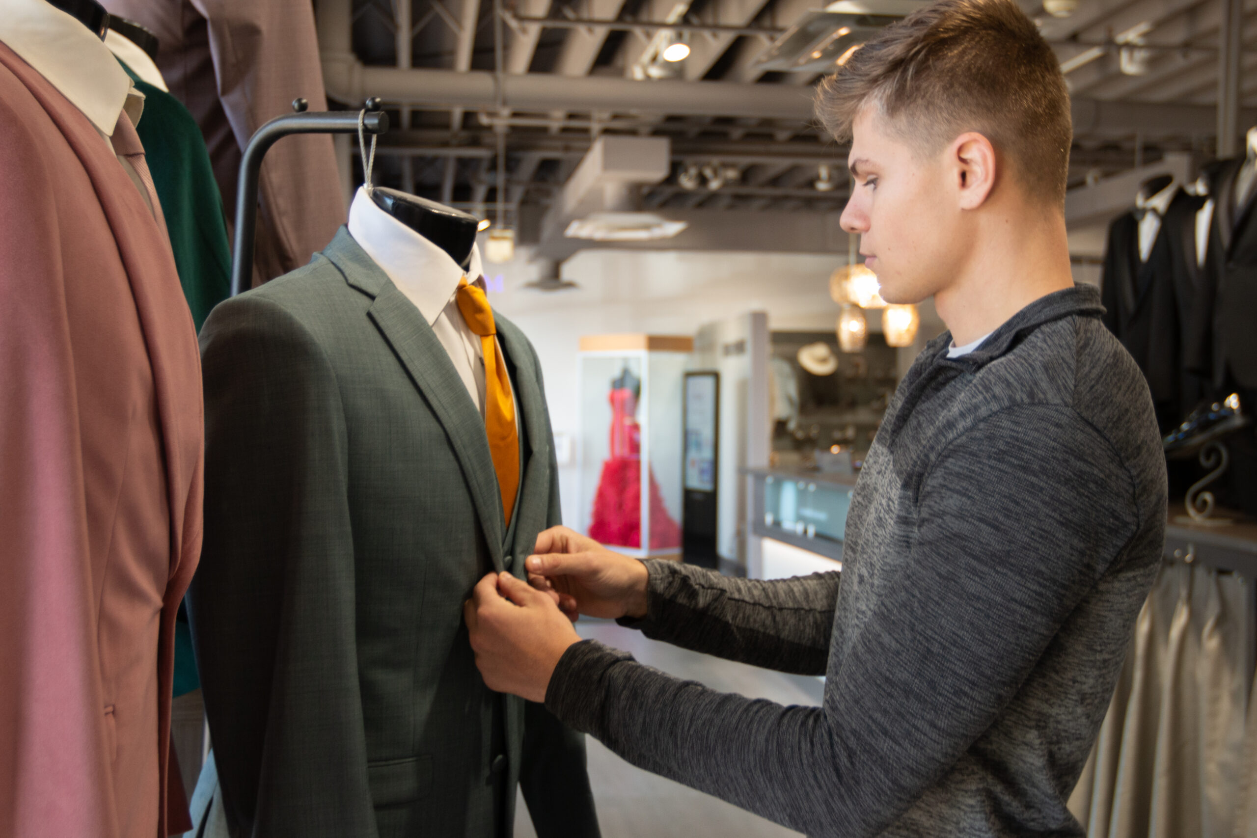 Picture at Modern Tux with someone shopping and looking at a Hunter Green Suit.